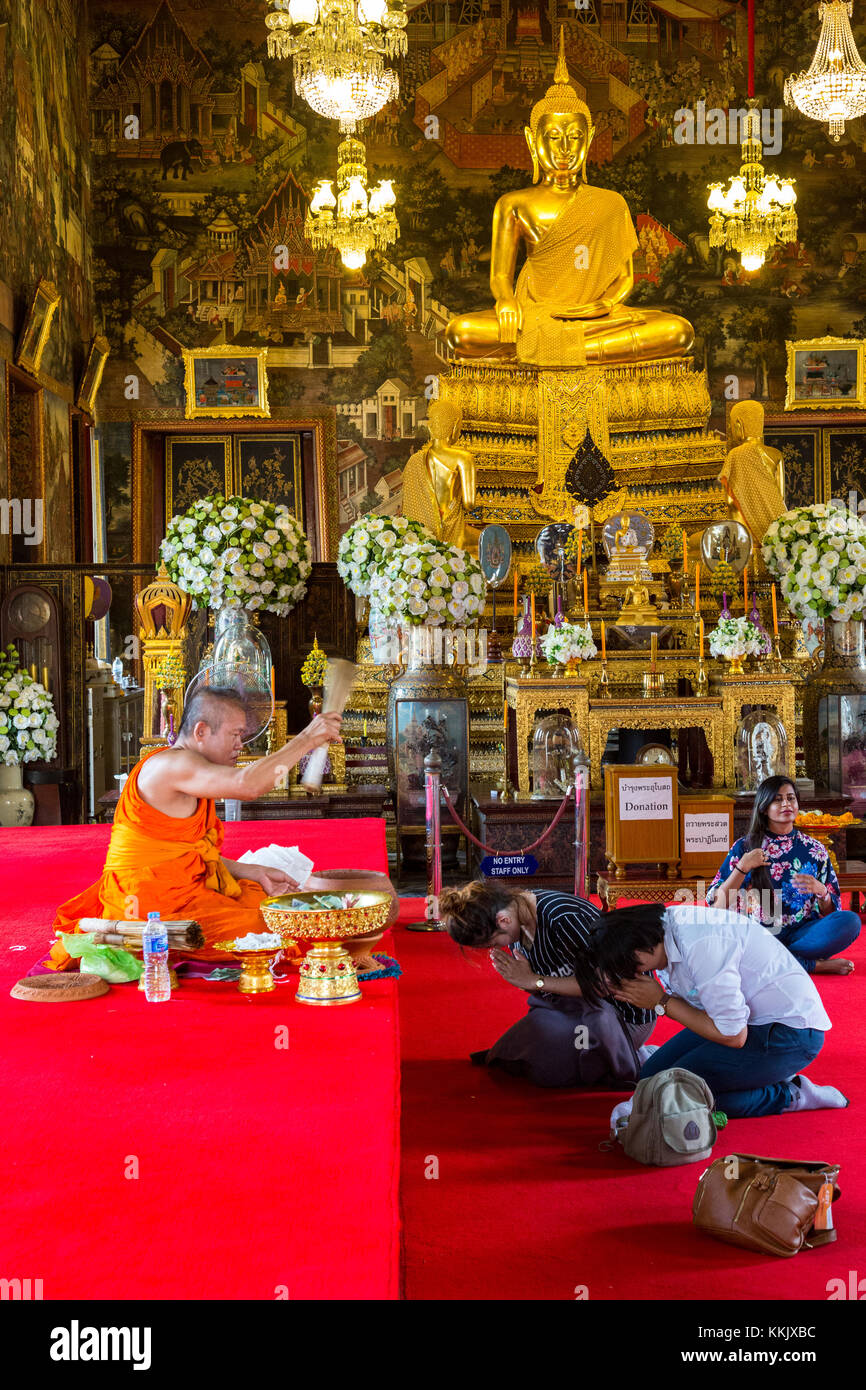 Bangkok, Thailand. Ein Paar erhält ein Segen von einem buddhistischen Mönch in der ubosot des Wat Arun Tempel. Stockfoto