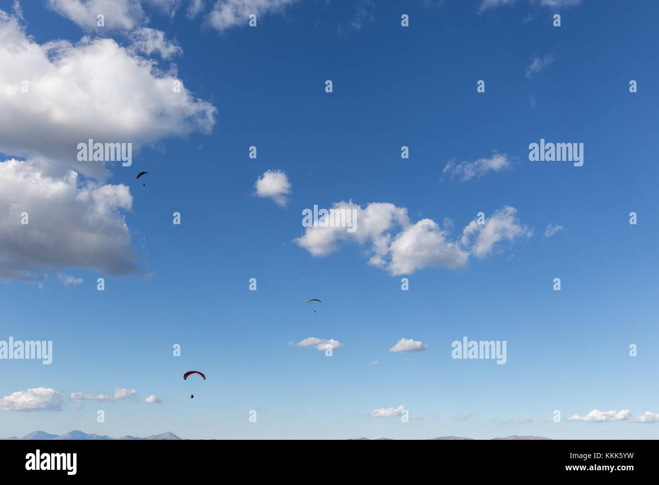 Drei para Segelflugzeuge gegen einen tiefen, blauen Himmel fliegen, mit großen weißen Wolken Stockfoto