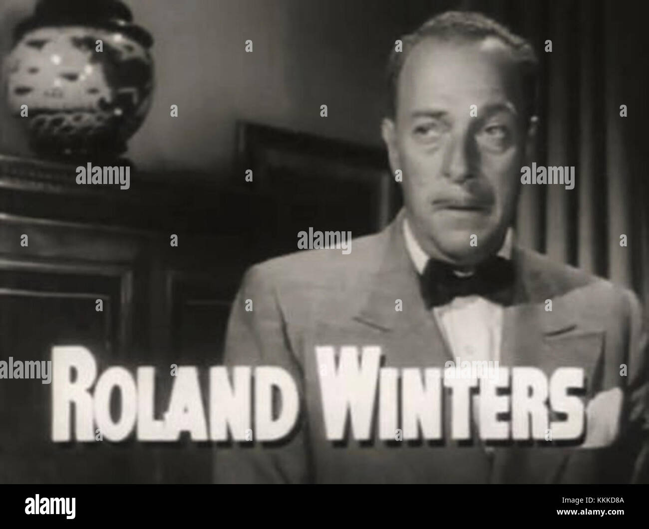 Roland Winters spielt die Hauptrolle im Trailer für den Film „A Dangerous Profession“. Das Bild fängt eine dramatische Szene aus dem Noir-Film ein, die Winters' Rolle unterstreicht. Stockfoto