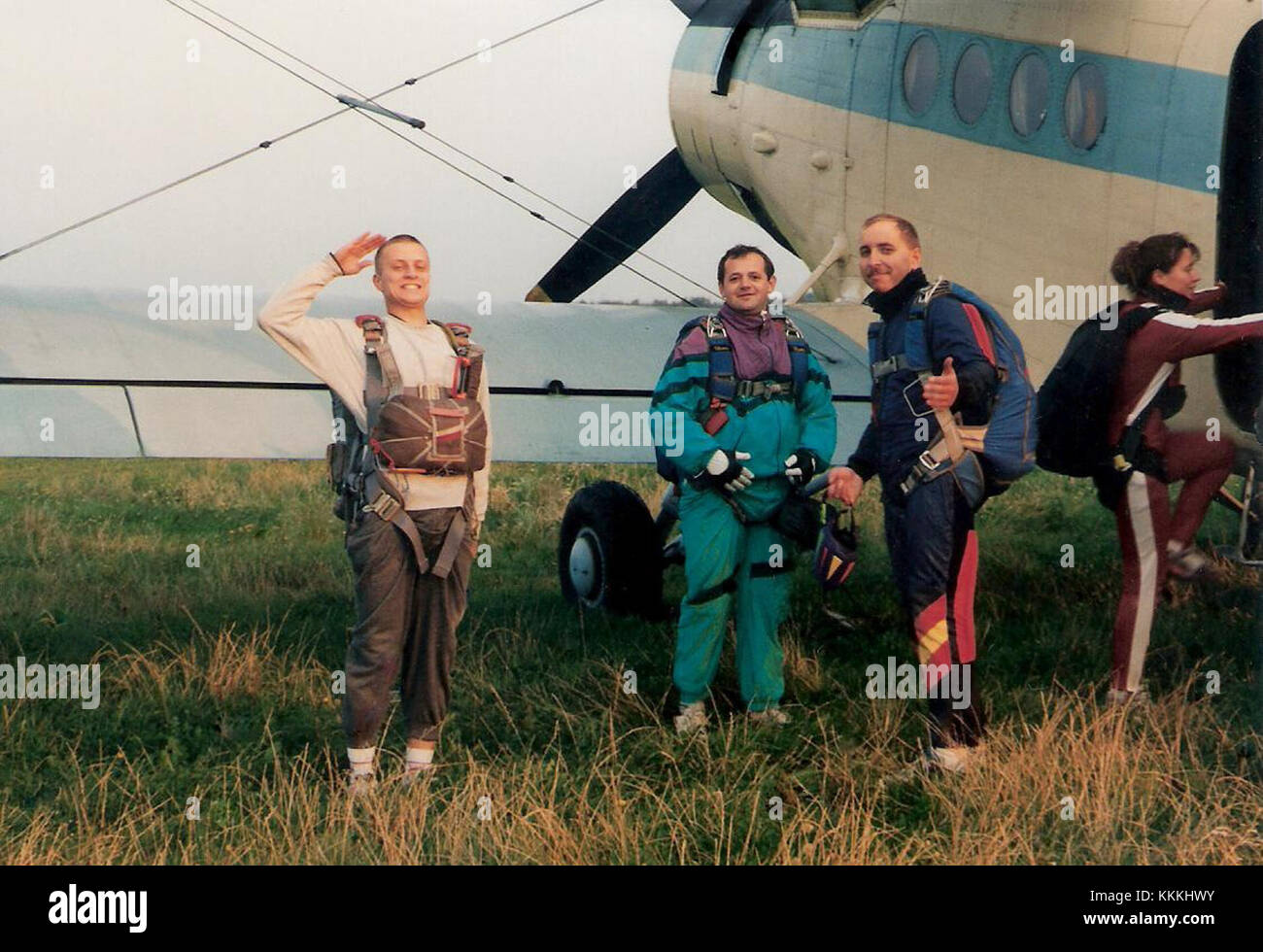 Dieses Foto zeigt Fallschirmspringer mit einem Antonov an-2 Flugzeug im Hintergrund. Das Bild zeigt die Verbindung zwischen Luftfahrt und Fallschirmspringen, wobei das Flugzeug als Startpunkt für den Sprung dient. Stockfoto
