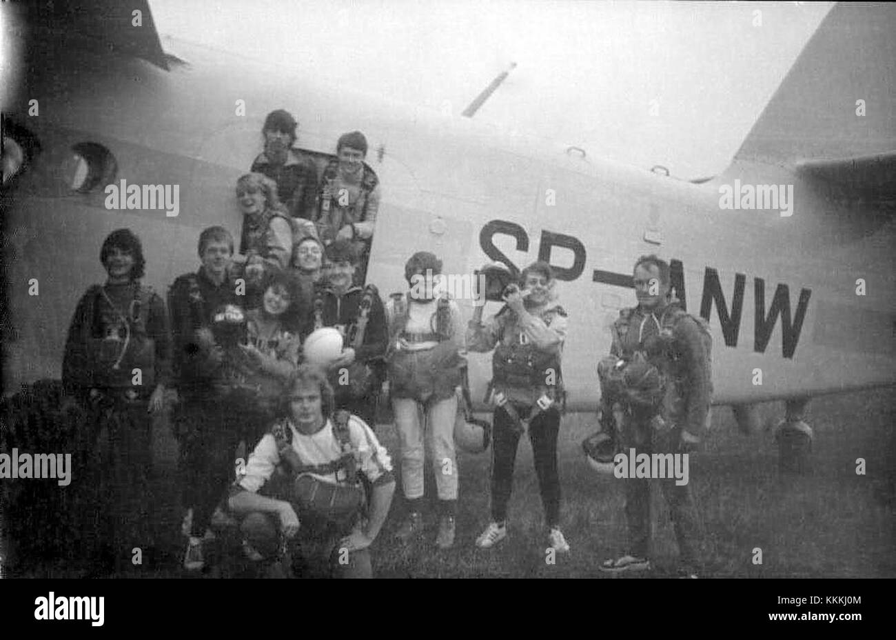 Ein Foto mit Fallschirmspringern in der Nähe eines Antonov an-2 Flugzeugs. Die an-2 ist ein Doppeldecker aus sowjetischer Zeit, bekannt für seine Vielseitigkeit in verschiedenen Rollen, unter anderem als Transport- und Landwirtschaftsflugzeug. Stockfoto