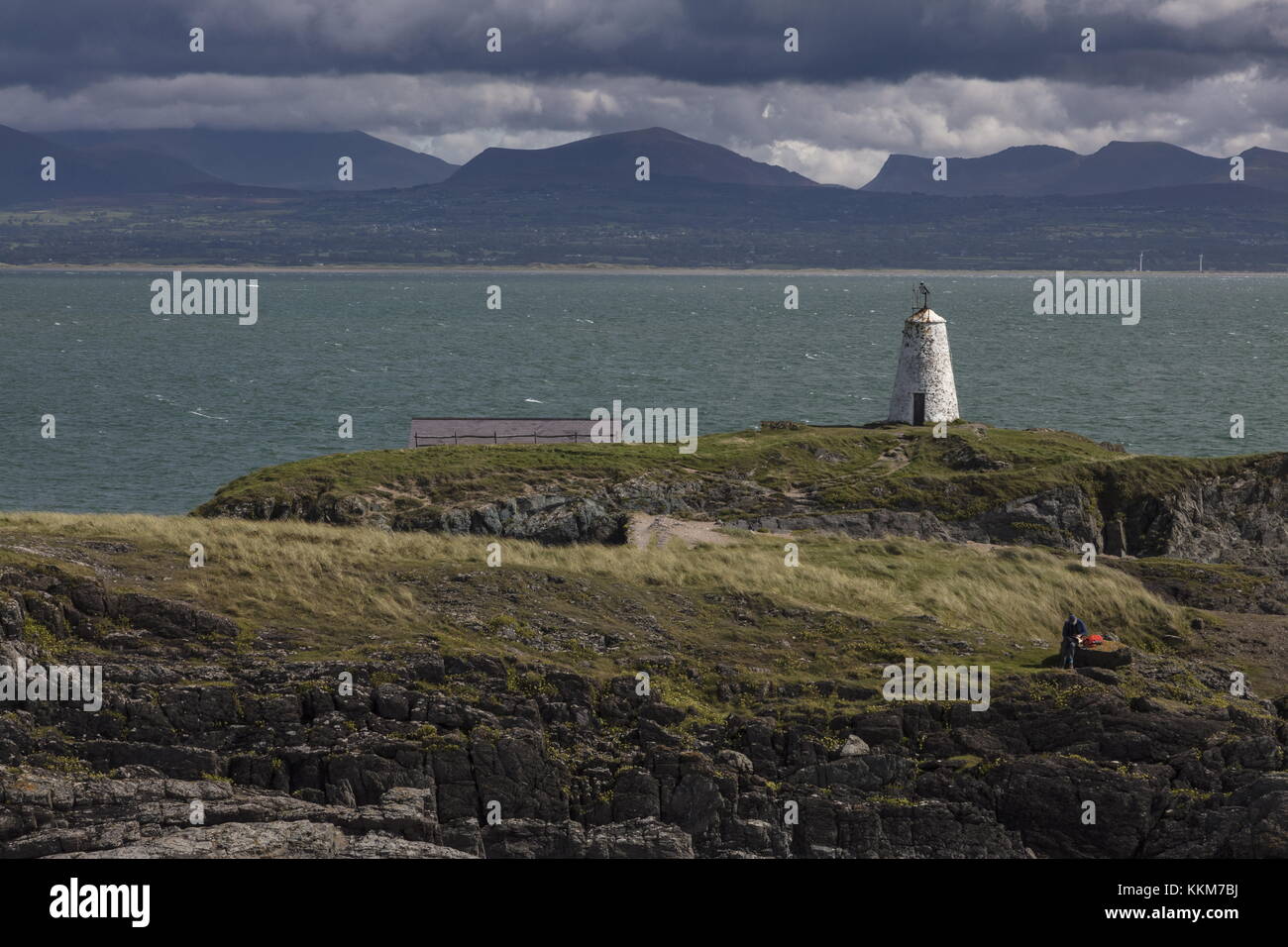 Twr Bach alten Leuchtturm, auf Ynys Llanddwyn mit Snowdonia darüber hinaus. Anglesey. Stockfoto