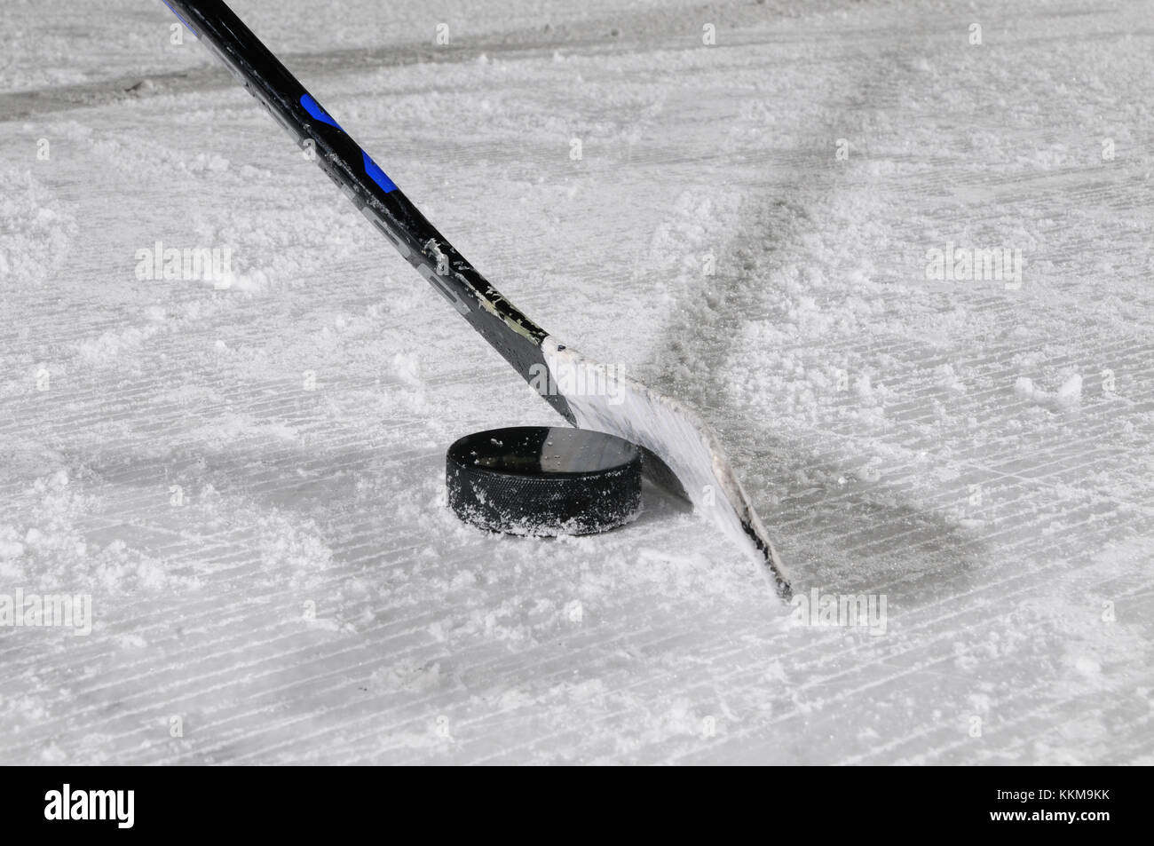 Ice Hockey Stick und Puck auf Eis, Nahaufnahme Stockfotografie Alamy