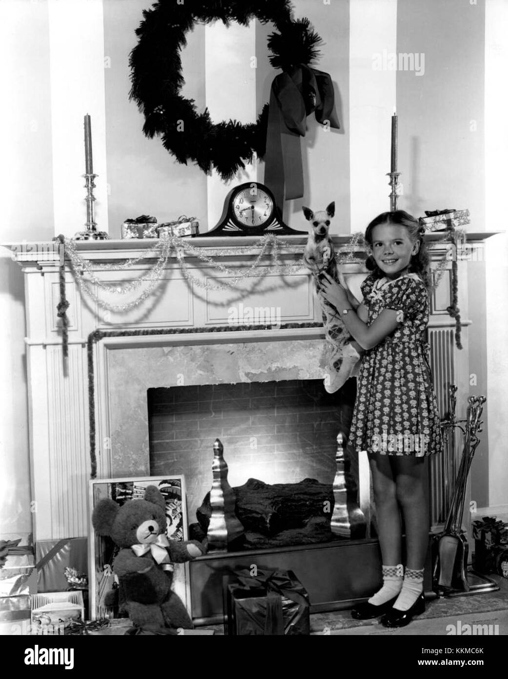 (Links) - Natalie Woods, 8-jährige Schauspielerin im 20th Century - Fox Studio, erzählt Folk nicht zu vergessen, ihre Strümpfe aufzuhängen. Ihr ist die richtige Größe, um Thunder, Mexikaner Chihuahua, zu halten, die ihr von Mitstreitern der Besetzung von 'Summer Lightning' gegeben wurde. Natalie Wood 1947 Stockfoto