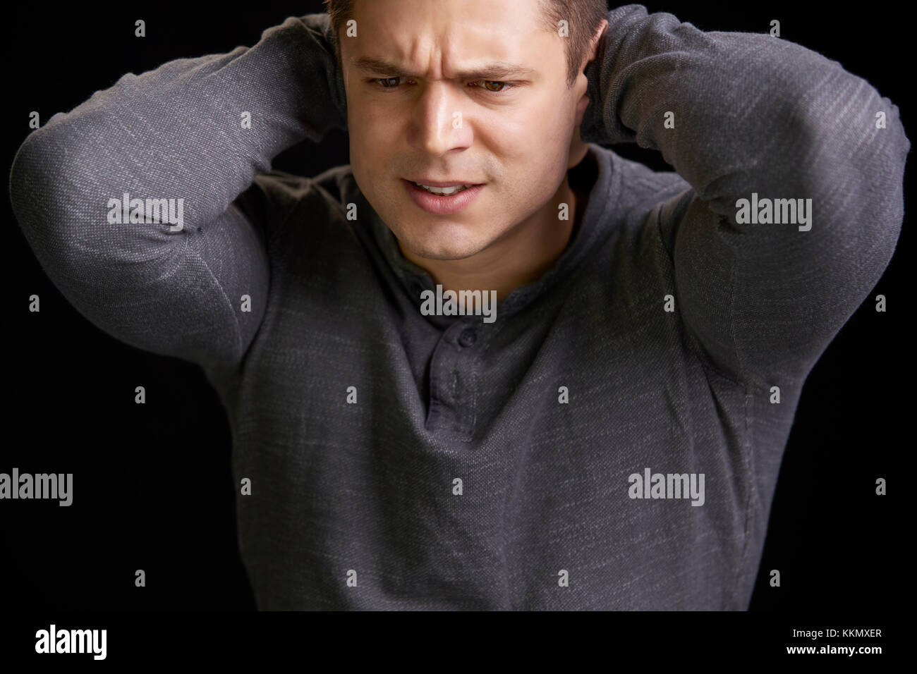 Portrait von wütenden jungen weißen Mann mit den Händen den Nacken Stockfoto