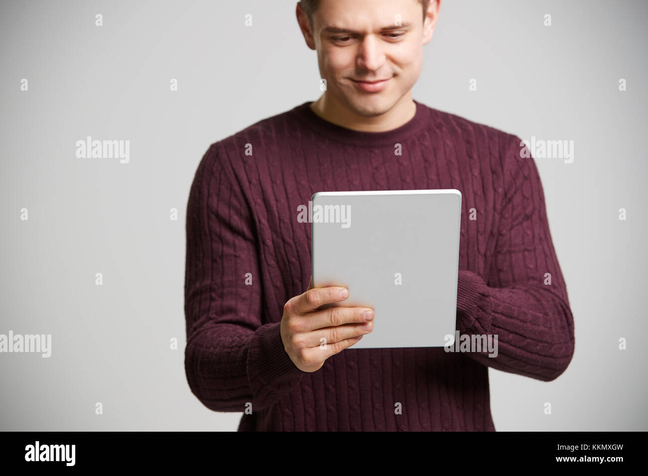 Lächelnden jungen weißen Mann hält einen Tablet-PC Stockfoto