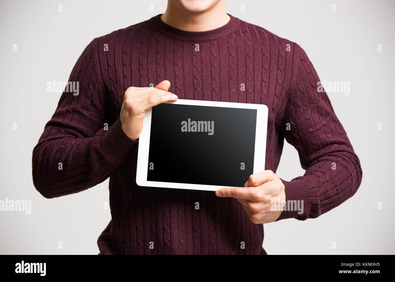 Junge Mann hält eine Tafel zeigt den Bildschirm, mittlere Partie Stockfoto