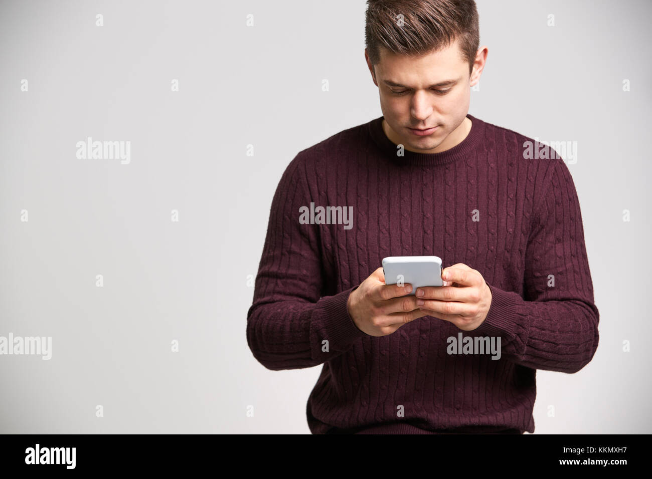 Porträt einer jungen weißen Mann mit einem Smartphone Stockfoto