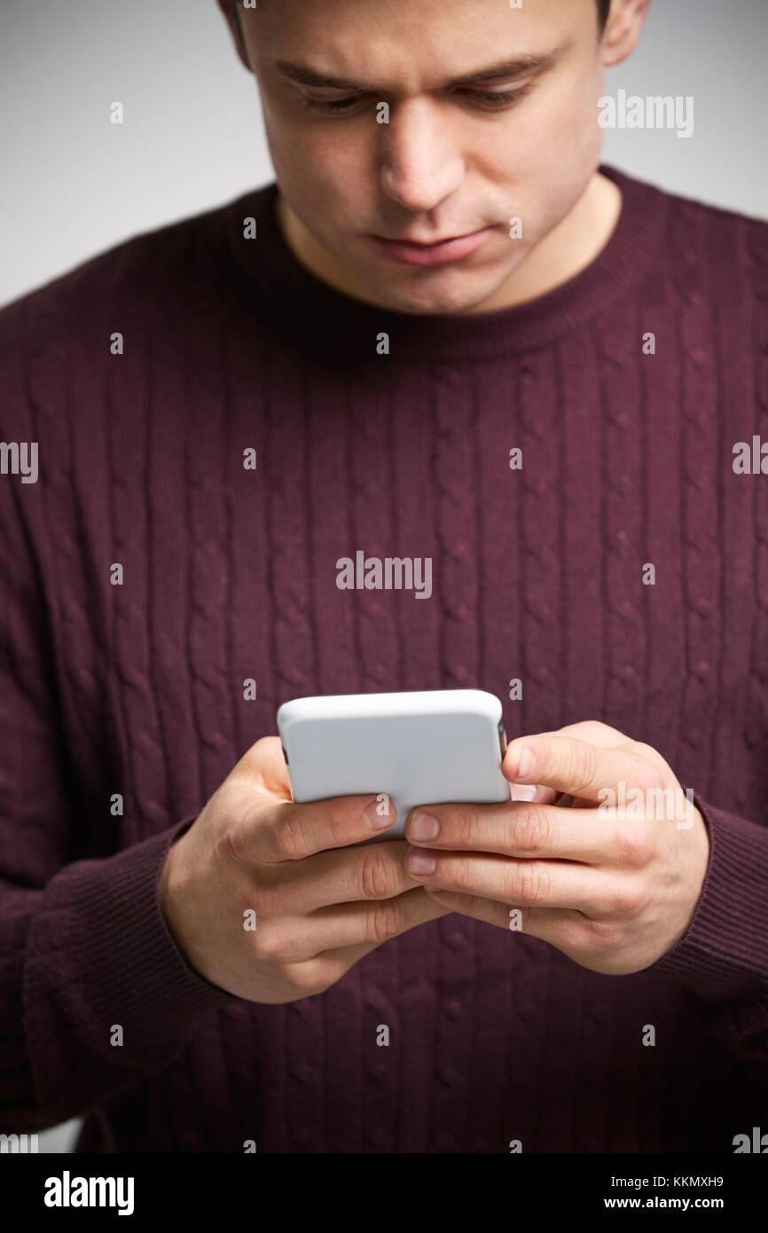 Vertikale Porträt einer jungen weißen Mann mit einem Smartphone Stockfoto