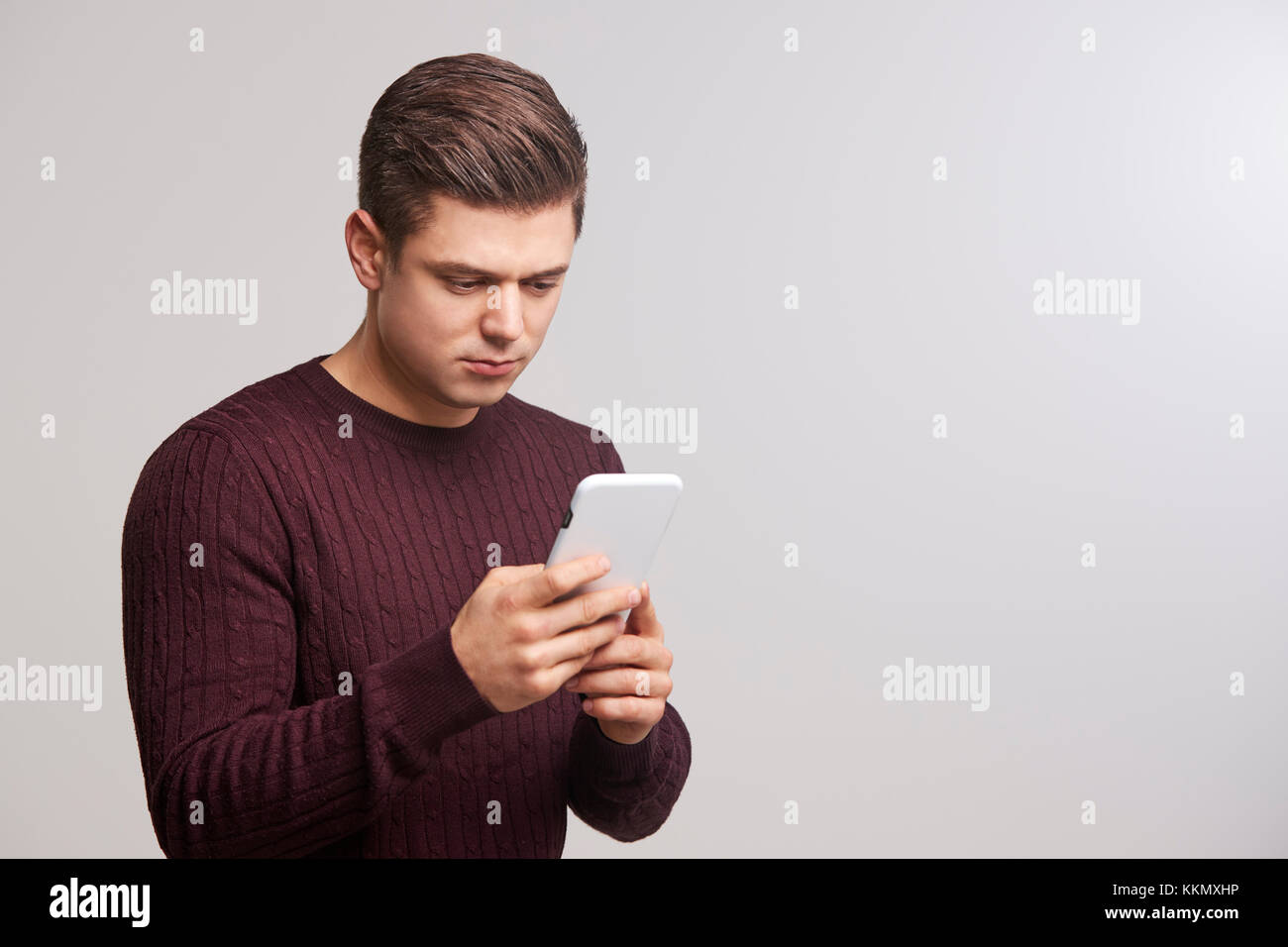 Porträt einer jungen weißen Mann mit einem Smartphone Stockfoto