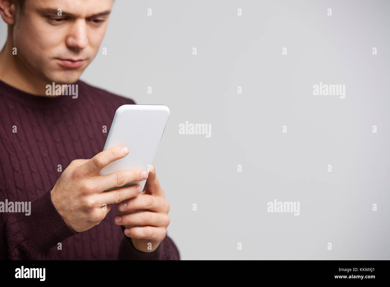 Porträt einer jungen weißen Mann mit einem Smartphone 7/8 Stockfoto