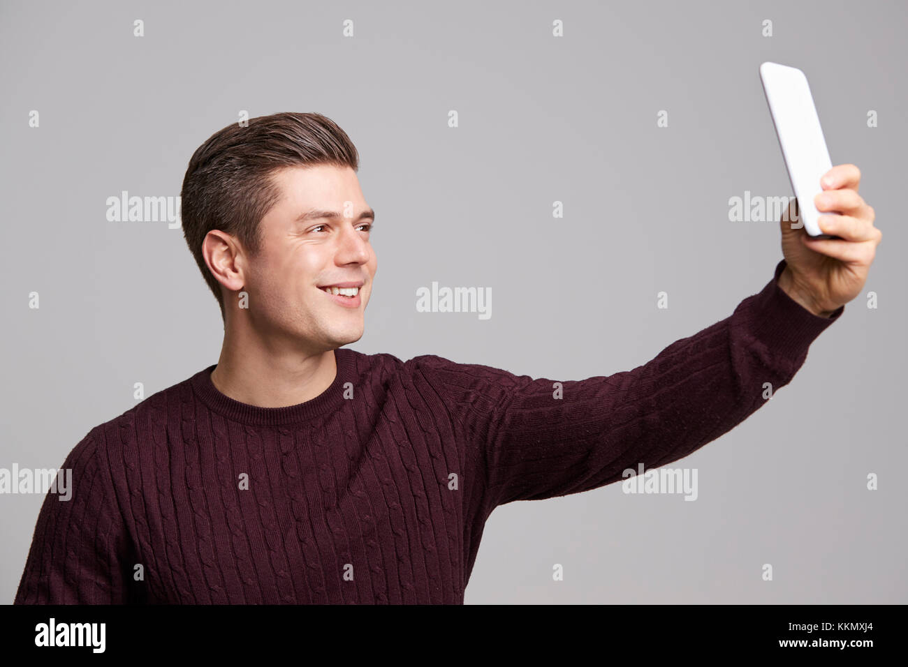 Ein lächelnder junger Mann eine selfie mit seinem Smartphone Stockfoto