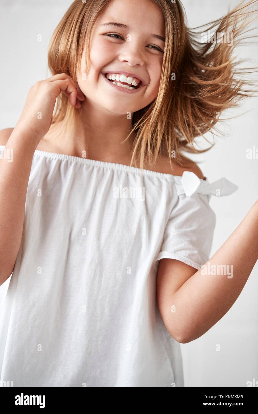 Glückliche junge Girl posiert im Studio gegen Weiße Wand Stockfoto