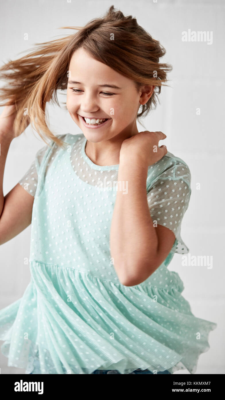 Glückliche junge Girl posiert im Studio gegen Weiße Wand Stockfoto