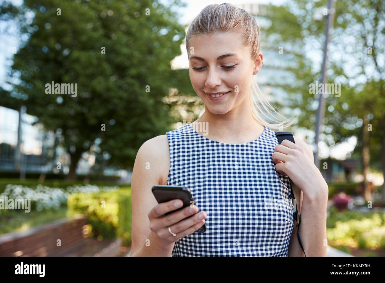 Geschäftsfrau zu Fuß zur Arbeit in Stadt in Handy suchen Stockfoto