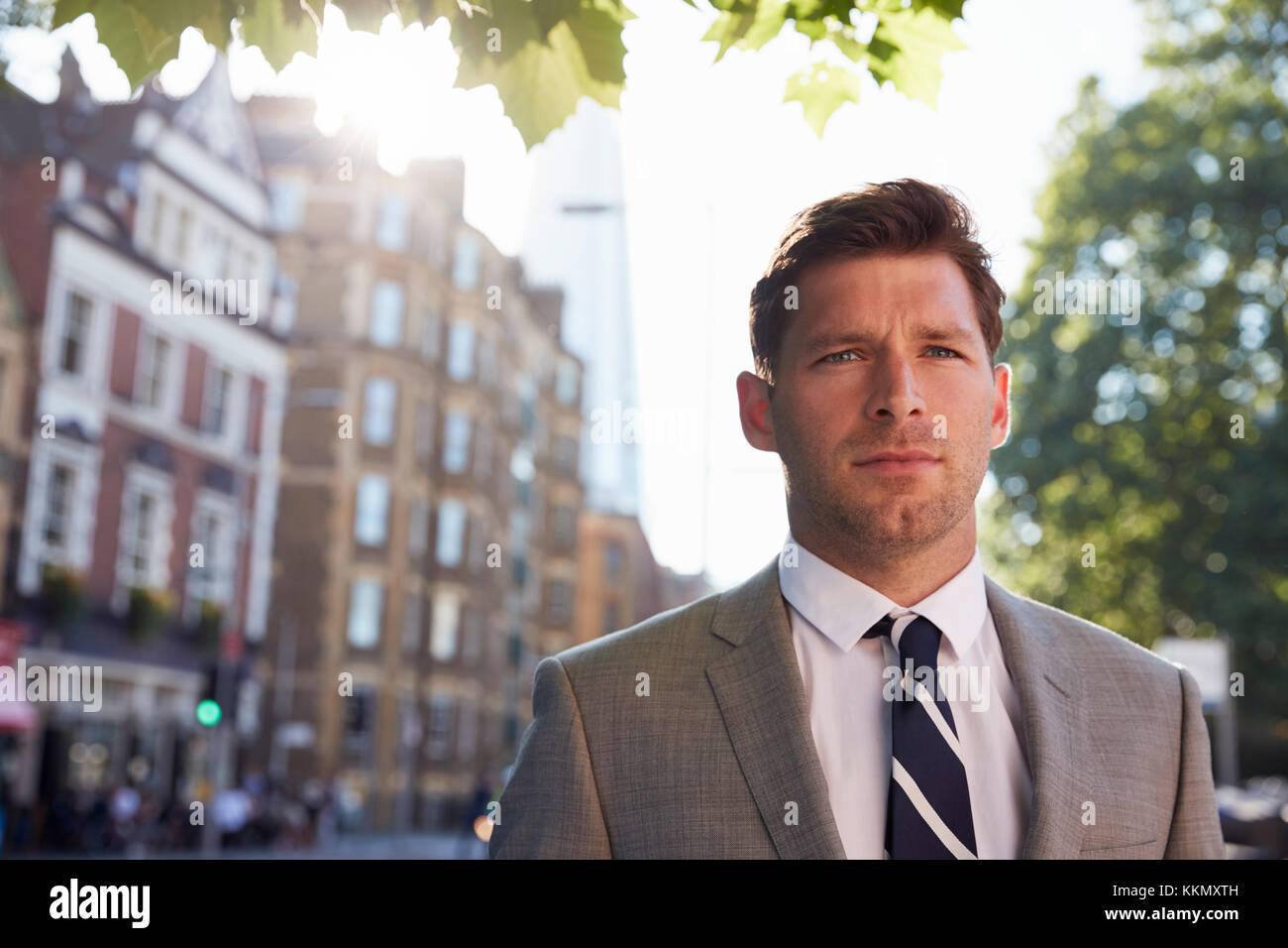 Portrait von Geschäftsmann zu Fuß zur Arbeit entlang City Street Stockfoto