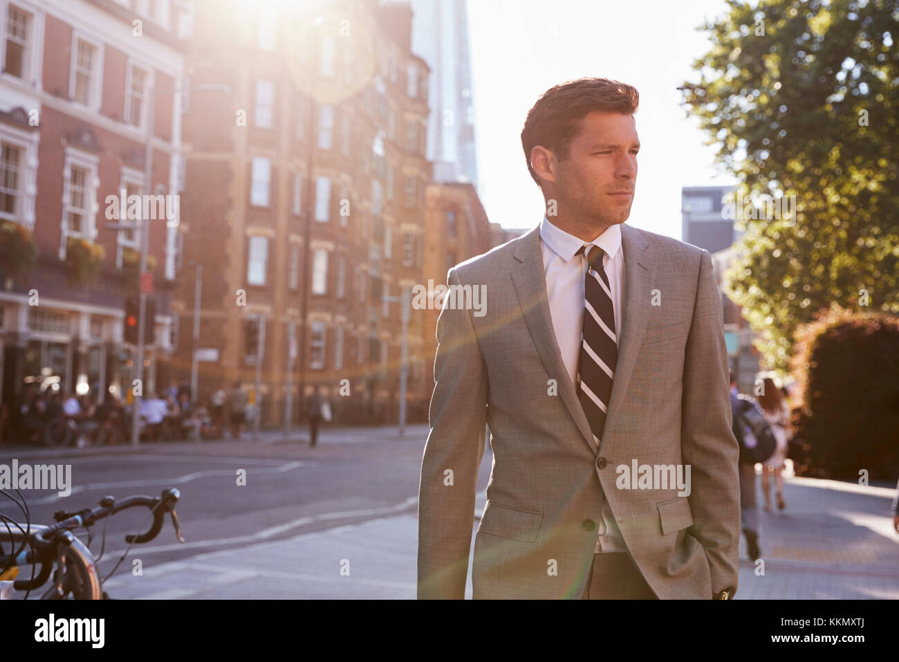 Geschäftsmann zu Fuß zur Arbeit entlang City Street Stockfoto