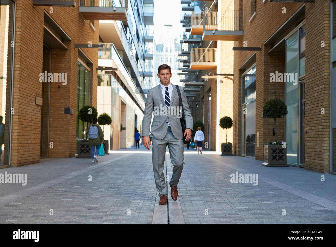 Geschäftsmann zu Fuß zur Arbeit entlang City Street Stockfoto