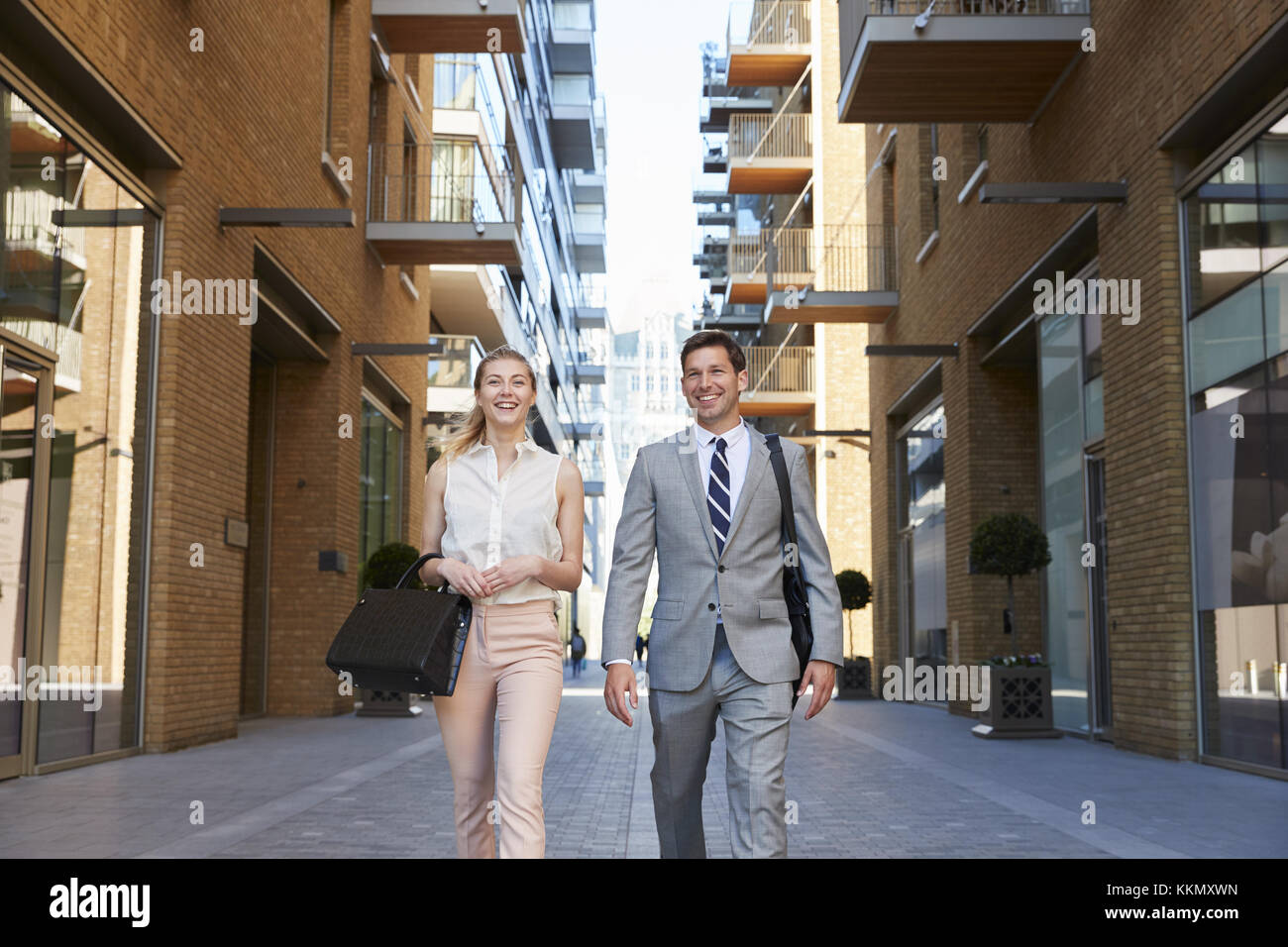 Geschäftsmann und Geschäftsfrau zu Fuß zur Arbeit durch die Stadt. Stockfoto