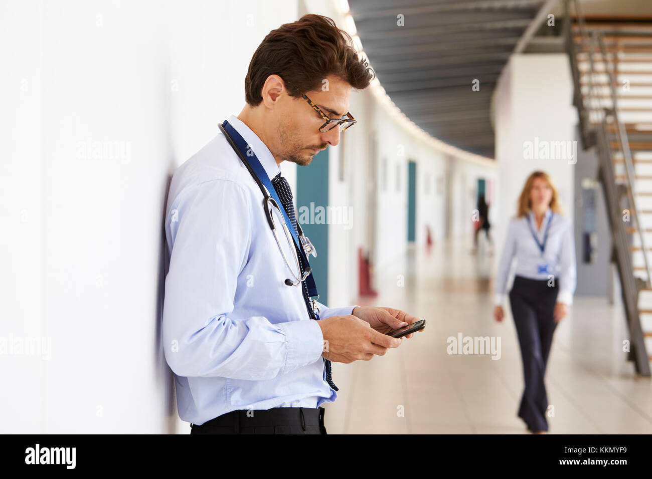 Portrait von jungen männlichen Arzt mit Stethoskop und Smartphone Stockfoto