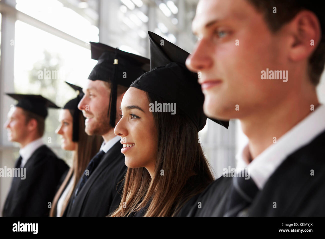 Glückliche Absolventen in Mörsern und Kleider, Kopf und Schultern Stockfoto