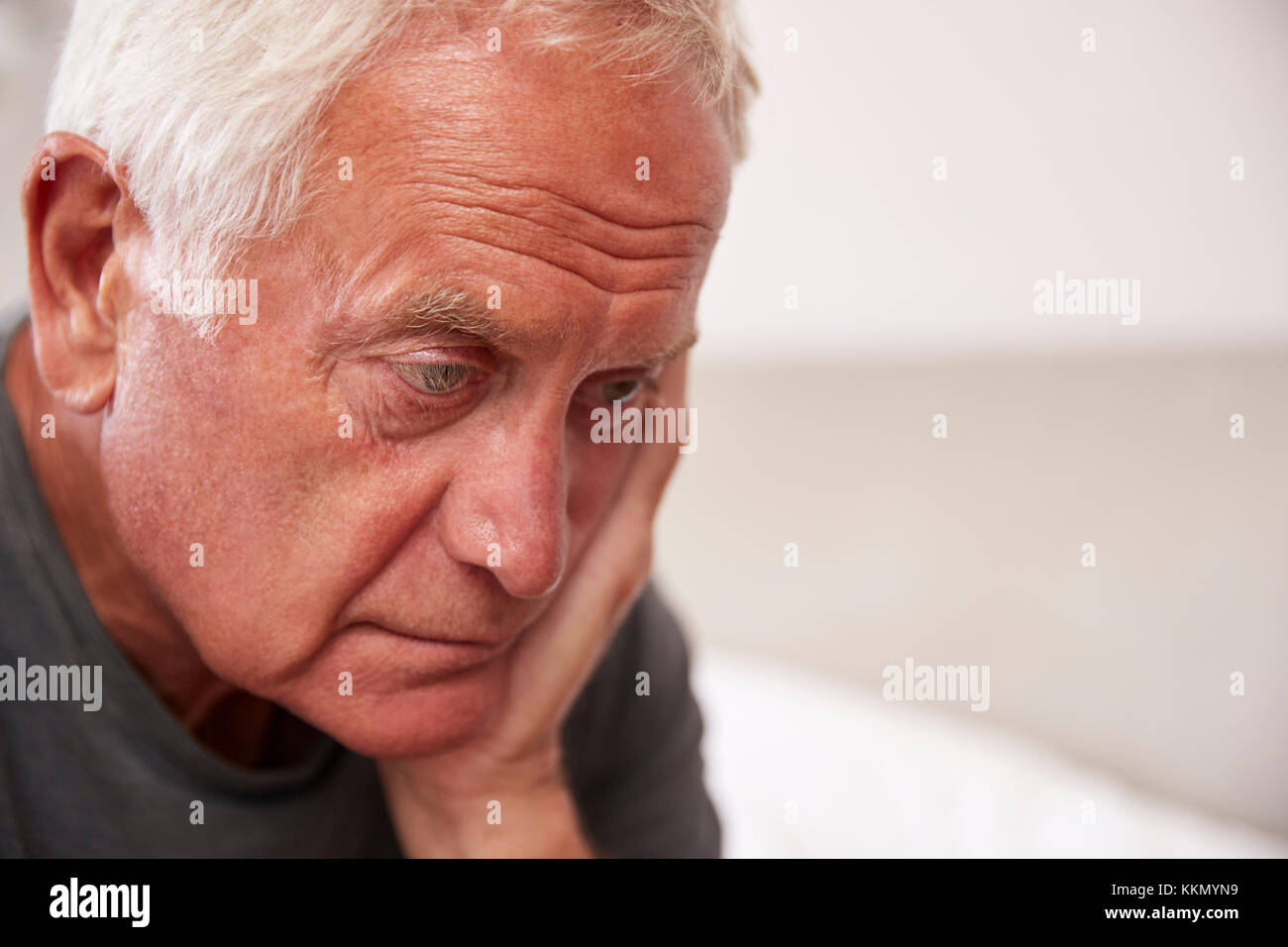 Älterer Mann sitzt auf dem Bett zu Hause, die unter Depressionen leiden Stockfoto