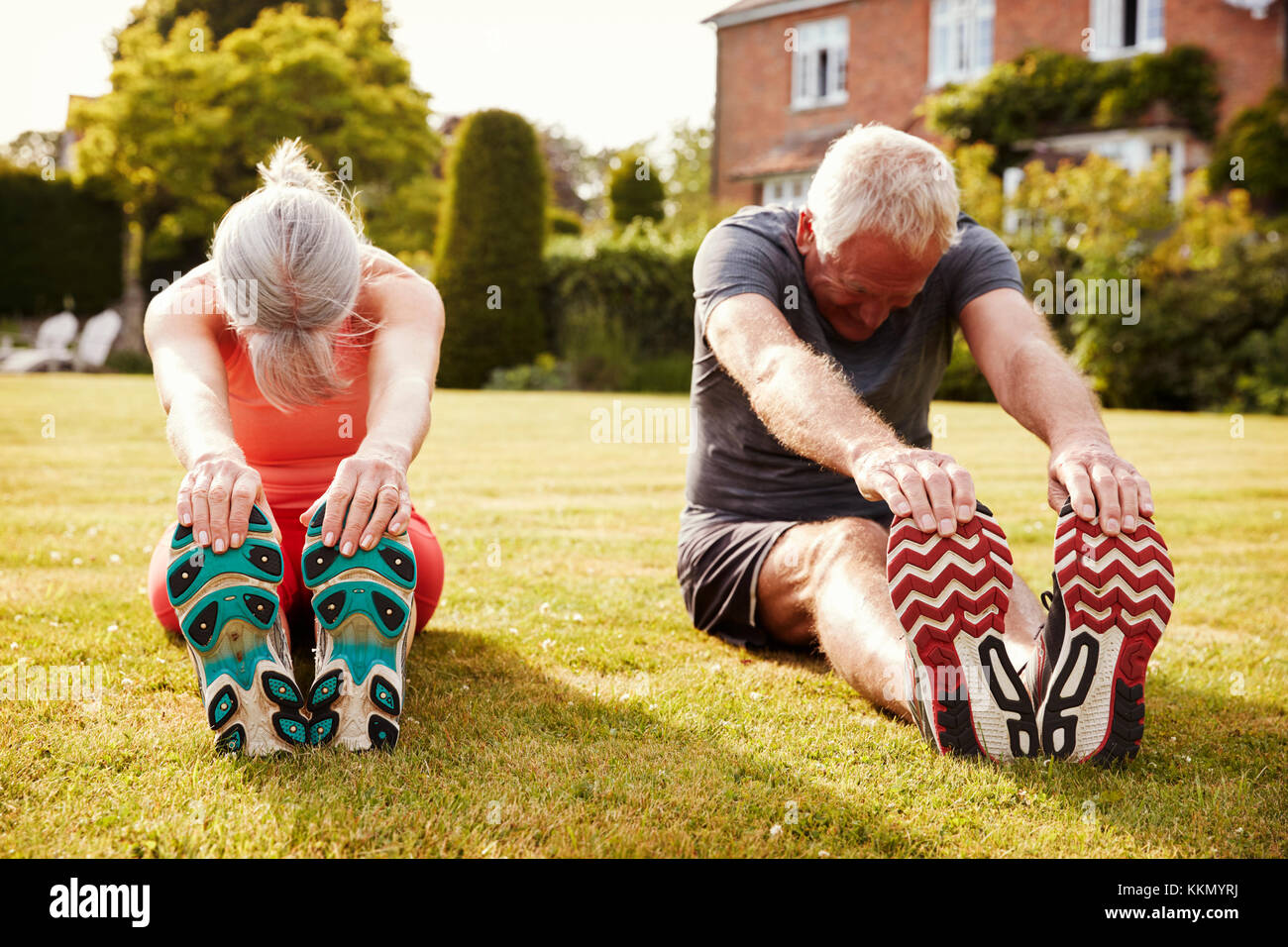Gesunde ältere Paare Trainieren in Garten zusammen Stockfoto