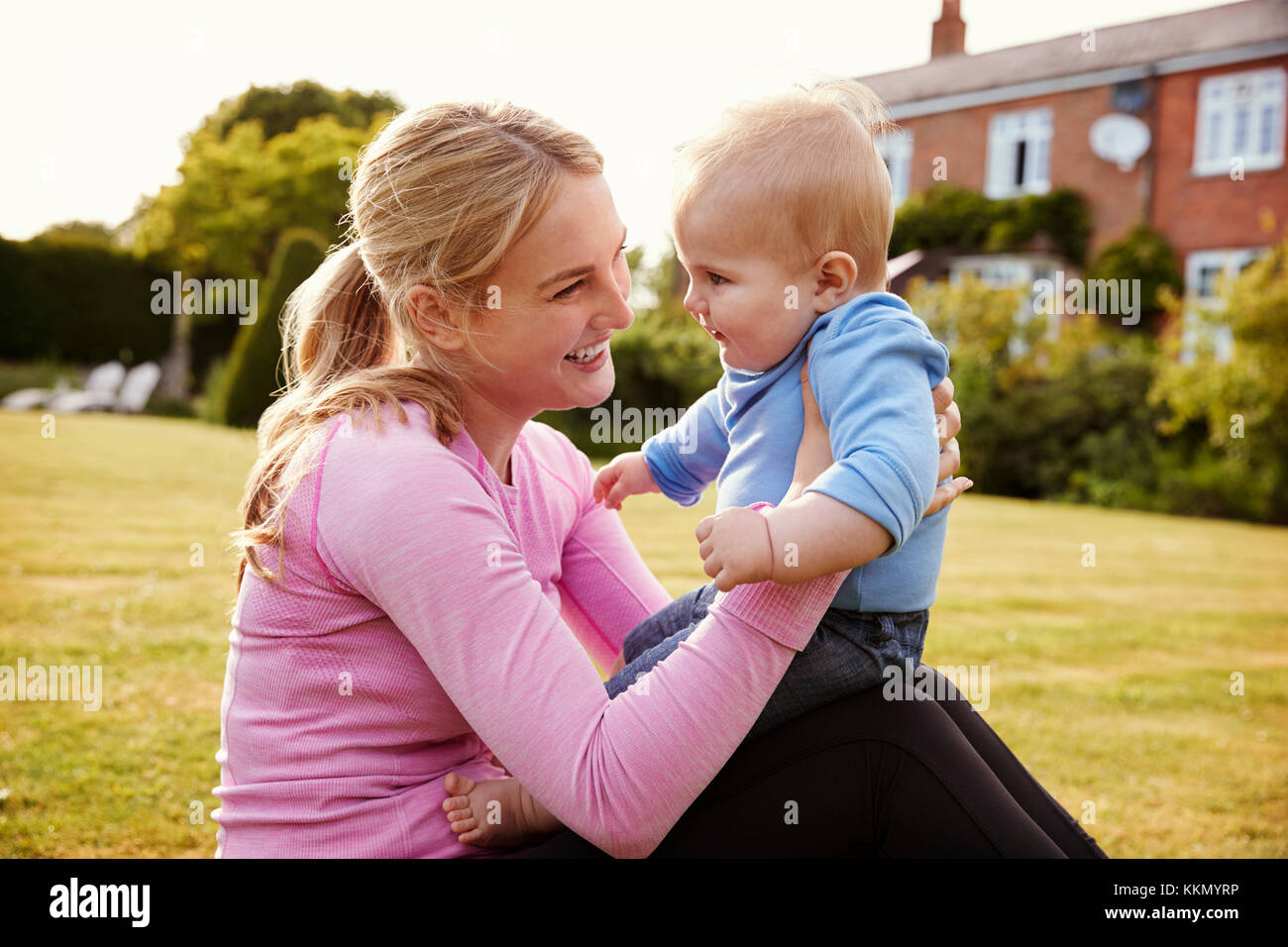 Mutter spielt im Garten mit Baby Sohn Stockfoto