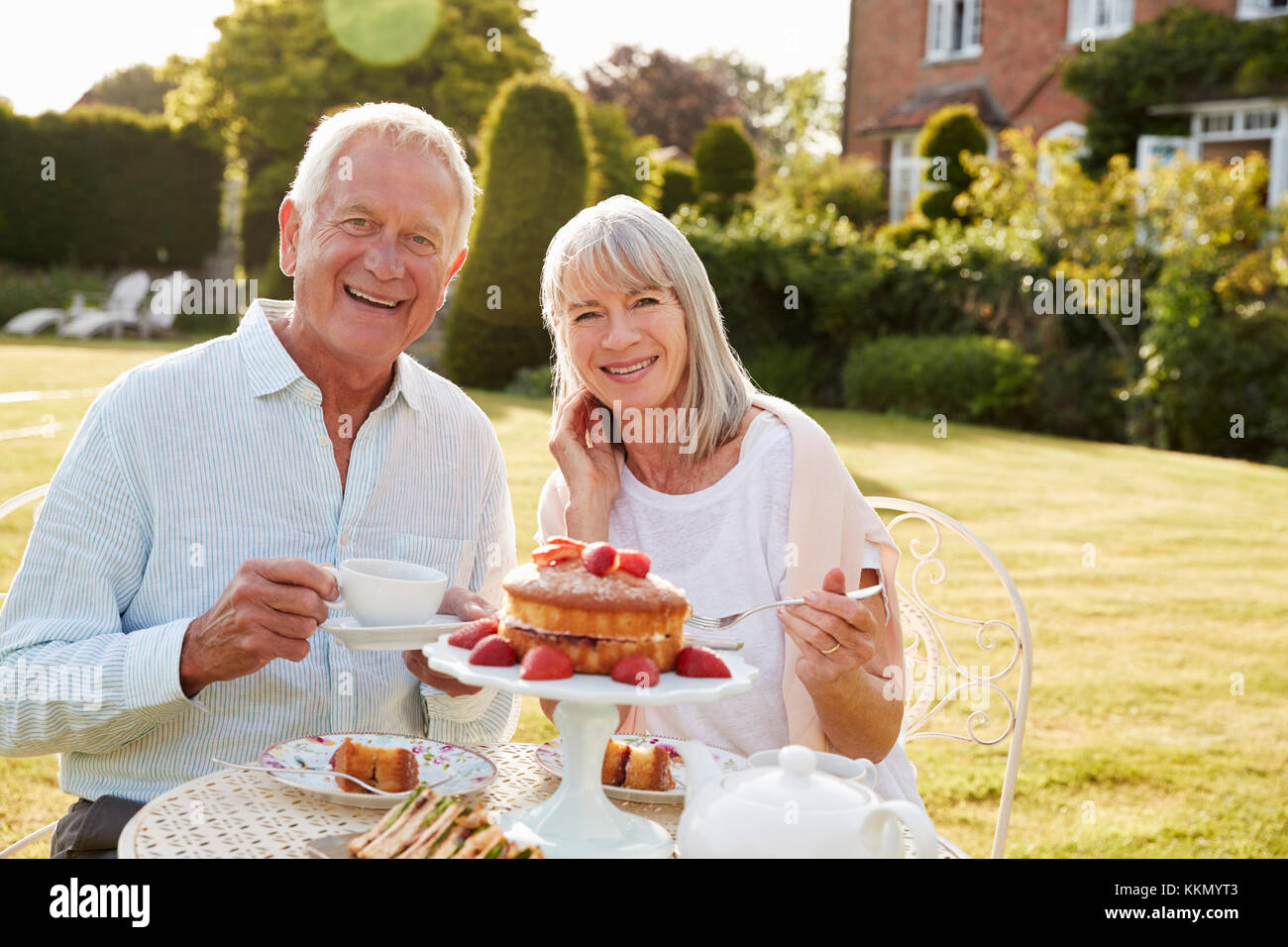 Rentnerehepaar genießen Nachmittagstee im Garten zu Hause Stockfoto