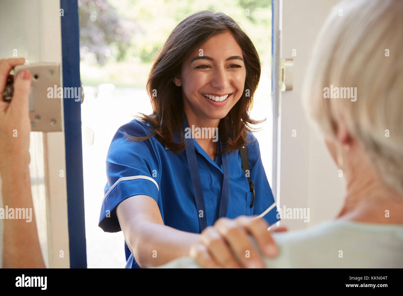 Krankenschwester auf Home Besuch begrüßt ältere Frau, über die Schulter sehen Stockfoto
