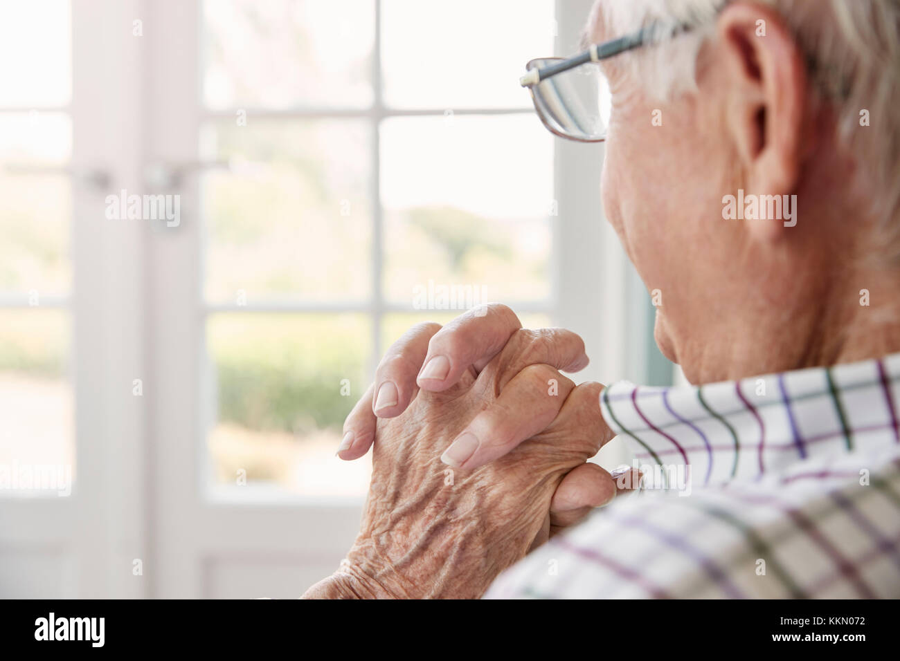 Älterer Mann sitzt aus dem Fenster zu Hause suchen, Nahaufnahme Stockfoto