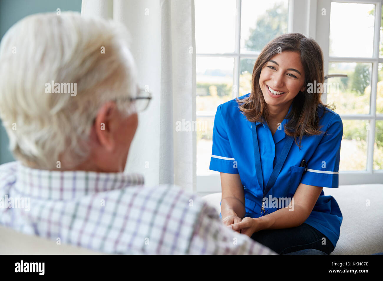 Blick über die Schulter der Krankenschwester zu Hause besuchen mit älterem Mann Stockfoto