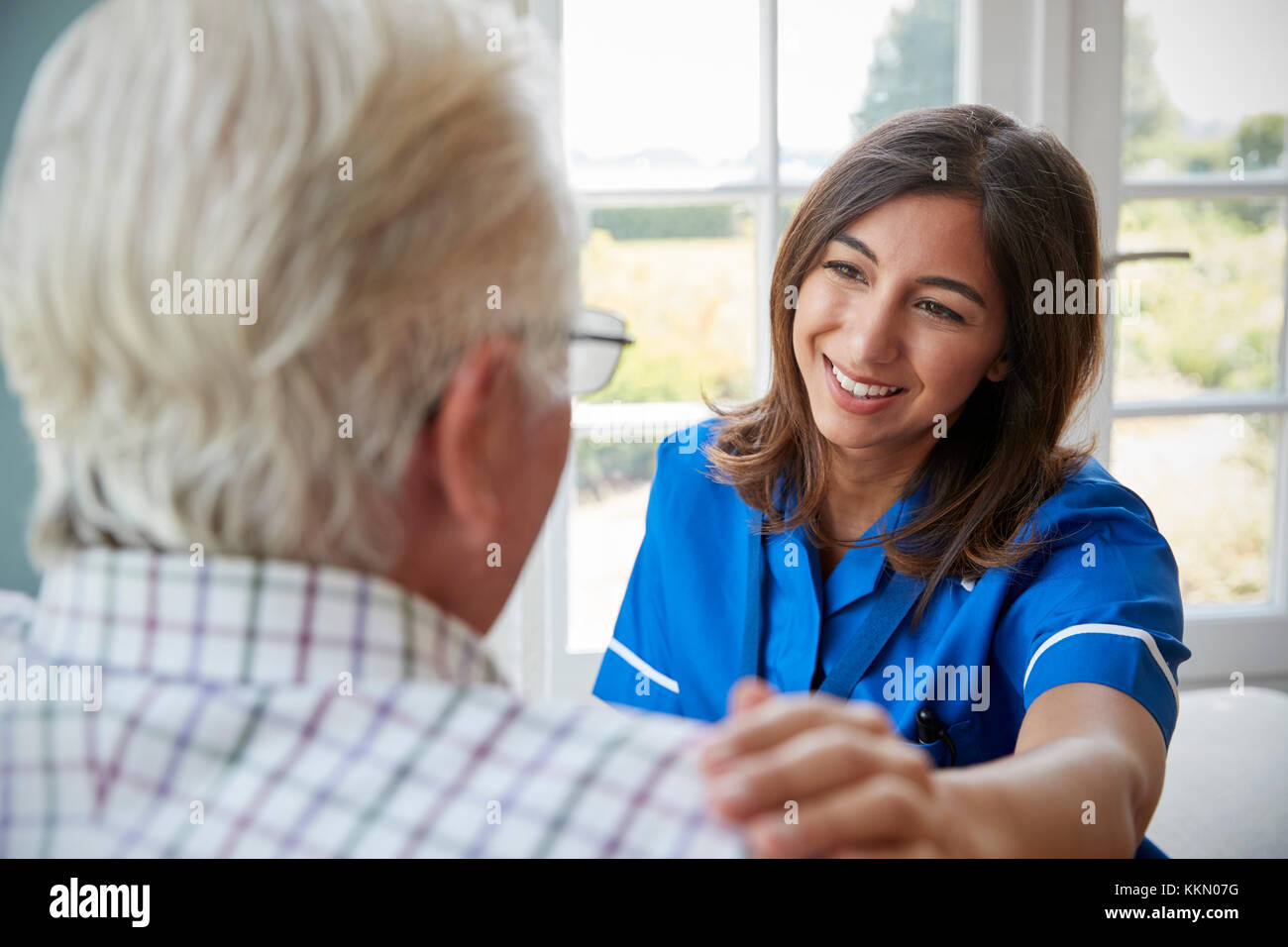 Blick über die Schulter der Krankenschwester zu Hause besuchen mit älterem Mann Stockfoto