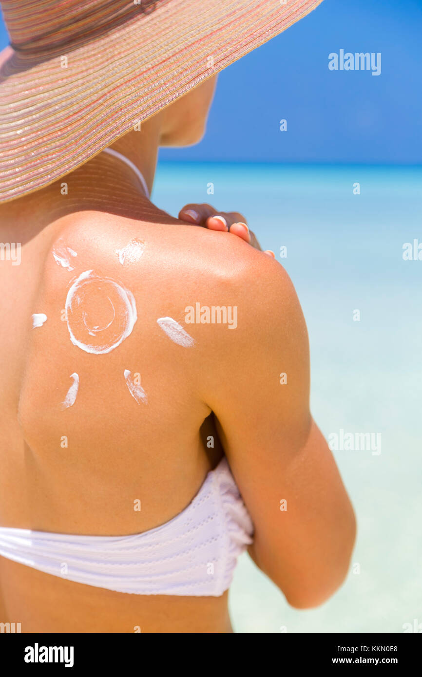 Sun lackiert mit Sonnencreme auf die Schulter bewusst über die Bedeutung von Schutz, wenn man auf Urlaub in sonnigen Plätzen zu machen. Stockfoto