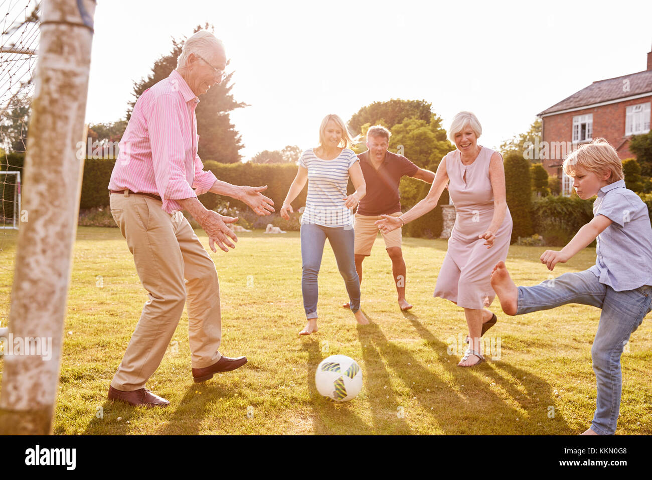 Multi-generation Familie Fußball spielen im Garten Stockfoto