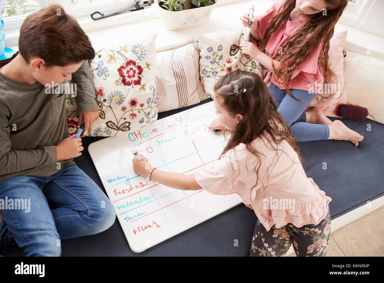 Kindern, die eine Liste mit Aufgaben auf dem Whiteboard zu Hause Stockfoto