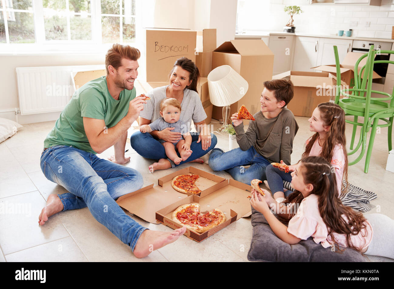 Familie feiern, Umzug in neues Zuhause mit Pizza Stockfoto