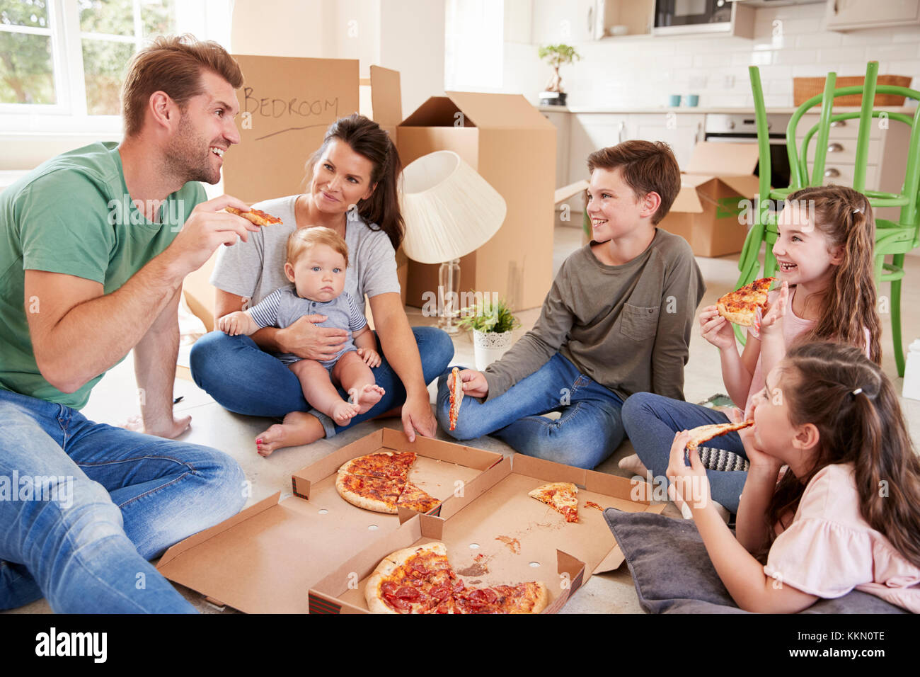 Familie feiern, Umzug in neues Zuhause mit Pizza Stockfoto