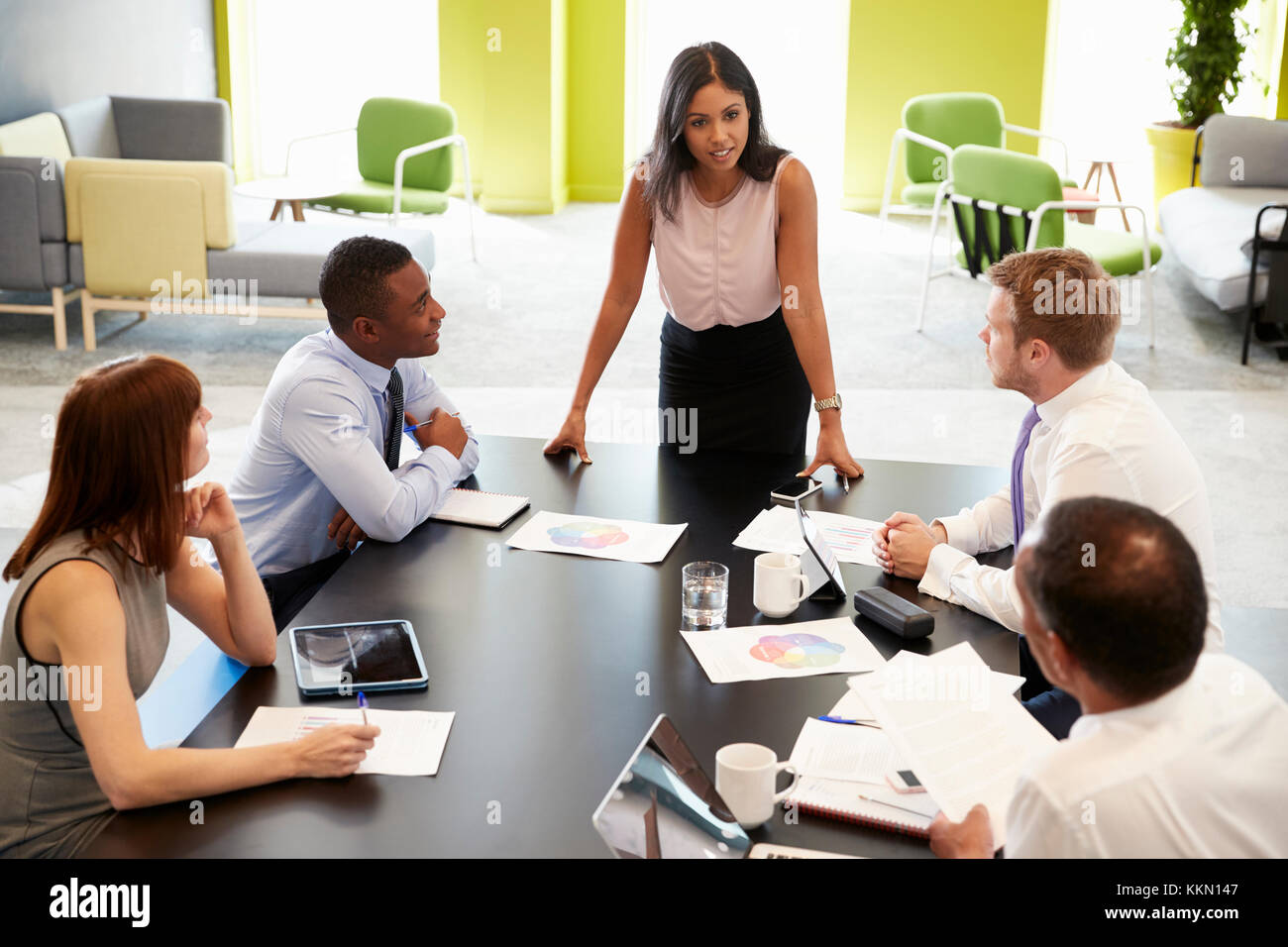 Weibliche boss stehend an informellen Treffen, Erhöhte Ansicht Stockfoto