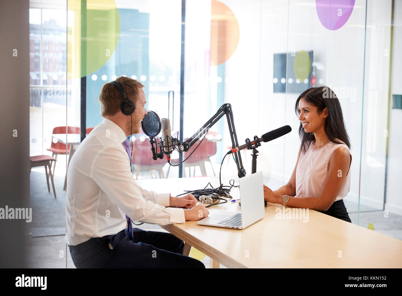 Junger Mann interviewt eine Frau im Radio Studio Stockfoto