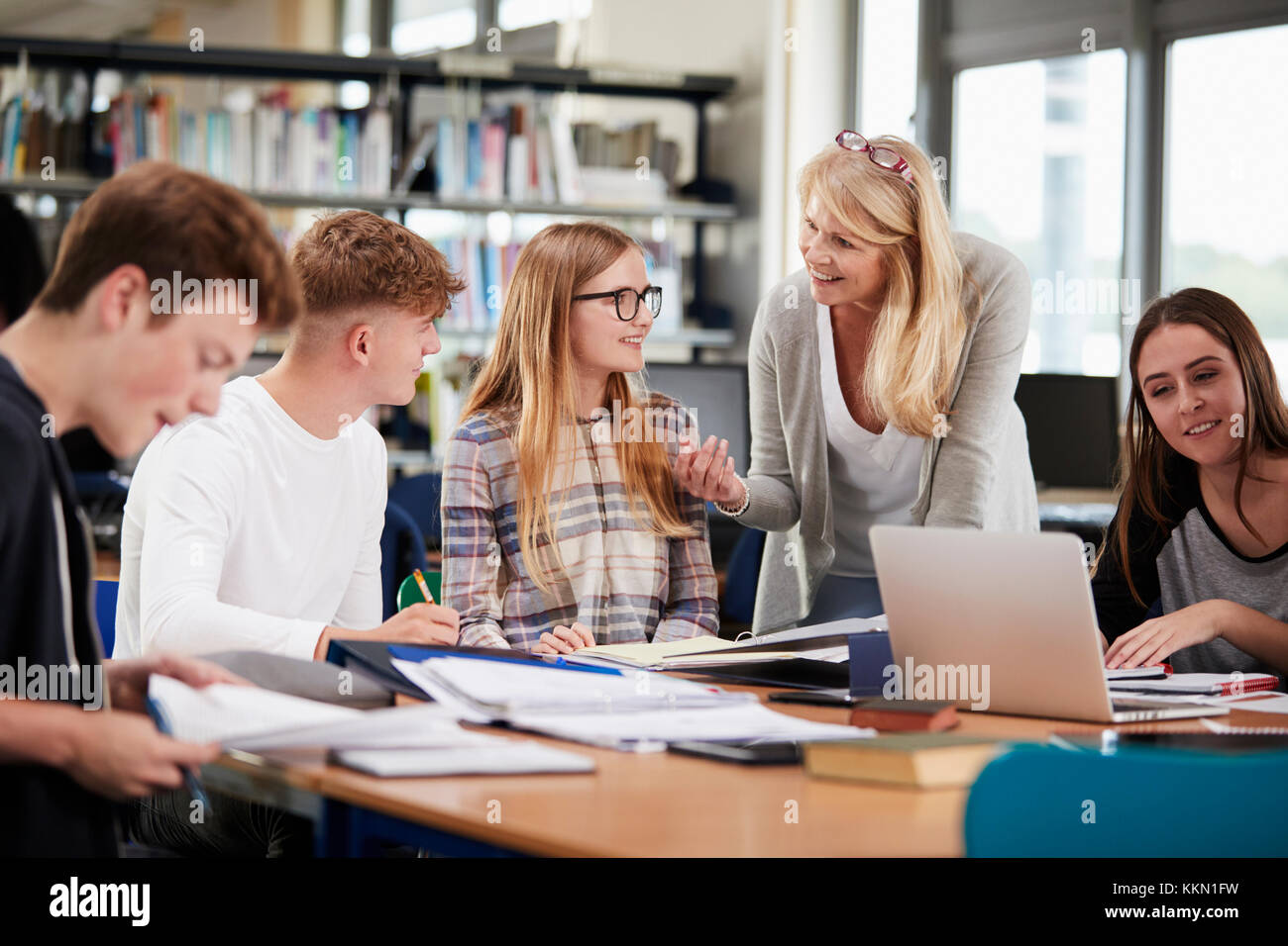 Lehrerin Arbeiten mit Studenten in Bibliothek Stockfoto