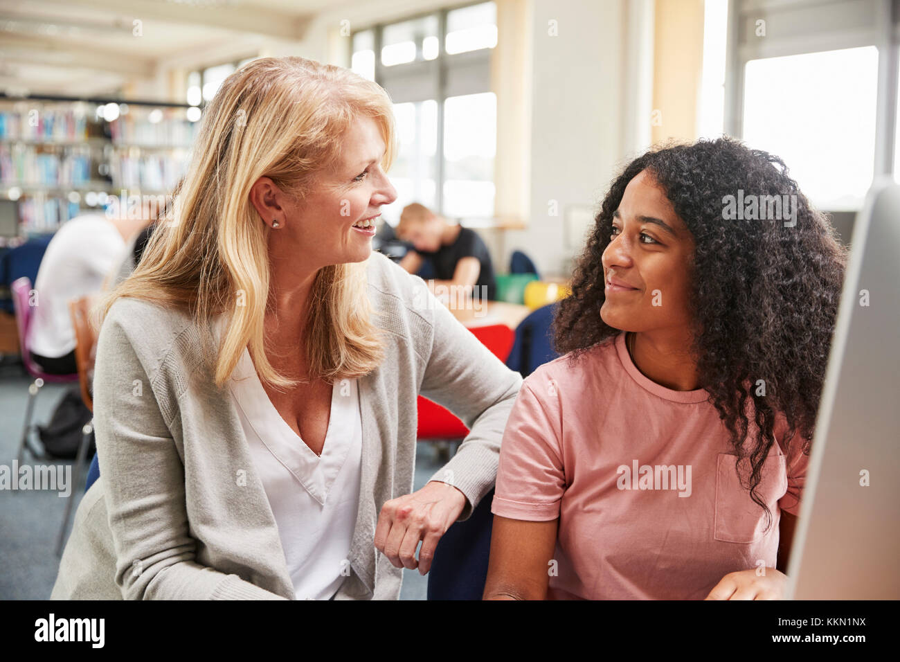 Lehrer und Schüler Arbeiten am Computer in der Hochschule Bibliothek Stockfoto