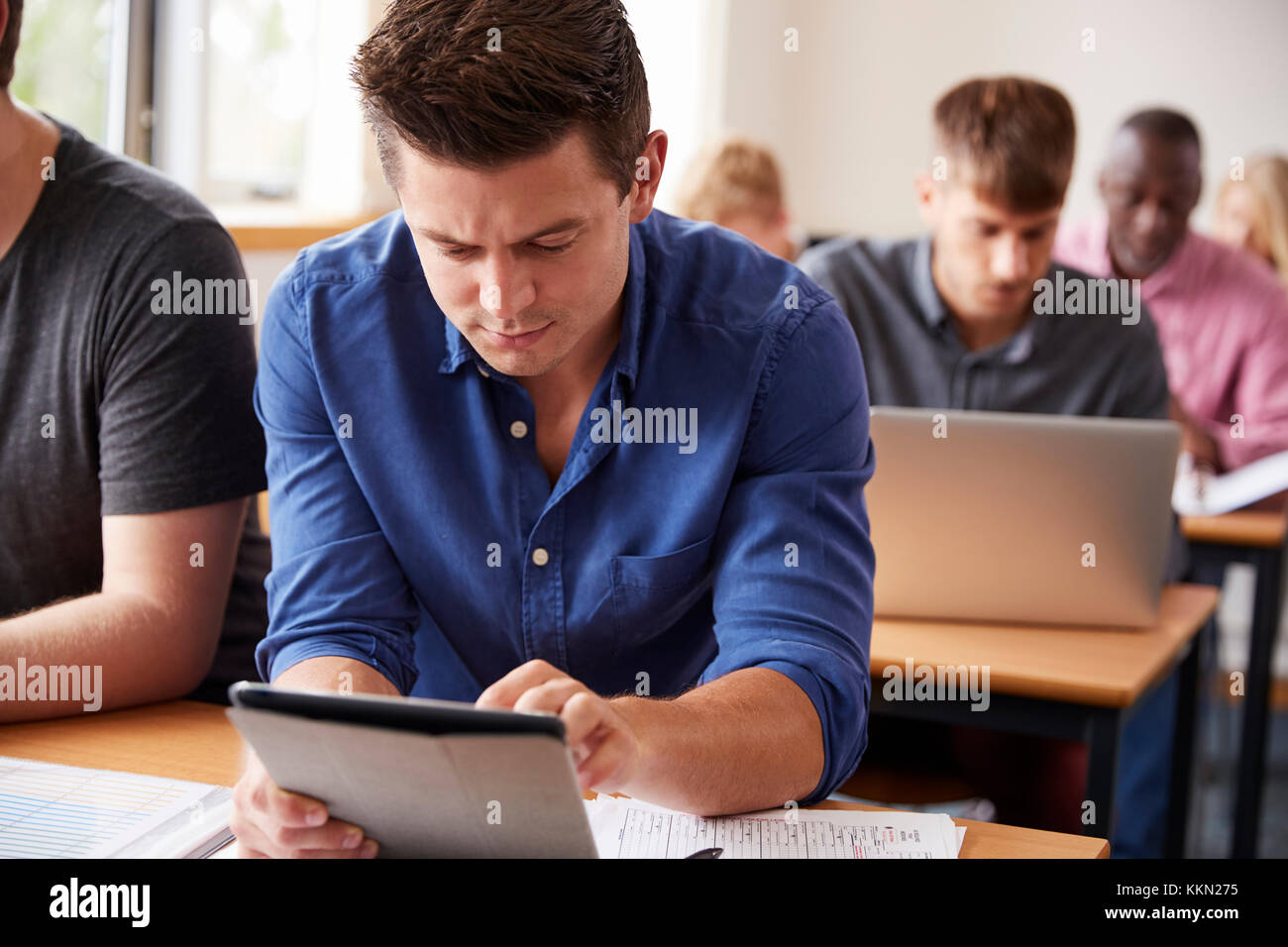 Reife männliche Kursteilnehmer mit digitalen Tablet in der Erwachsenenbildung Klasse Stockfoto