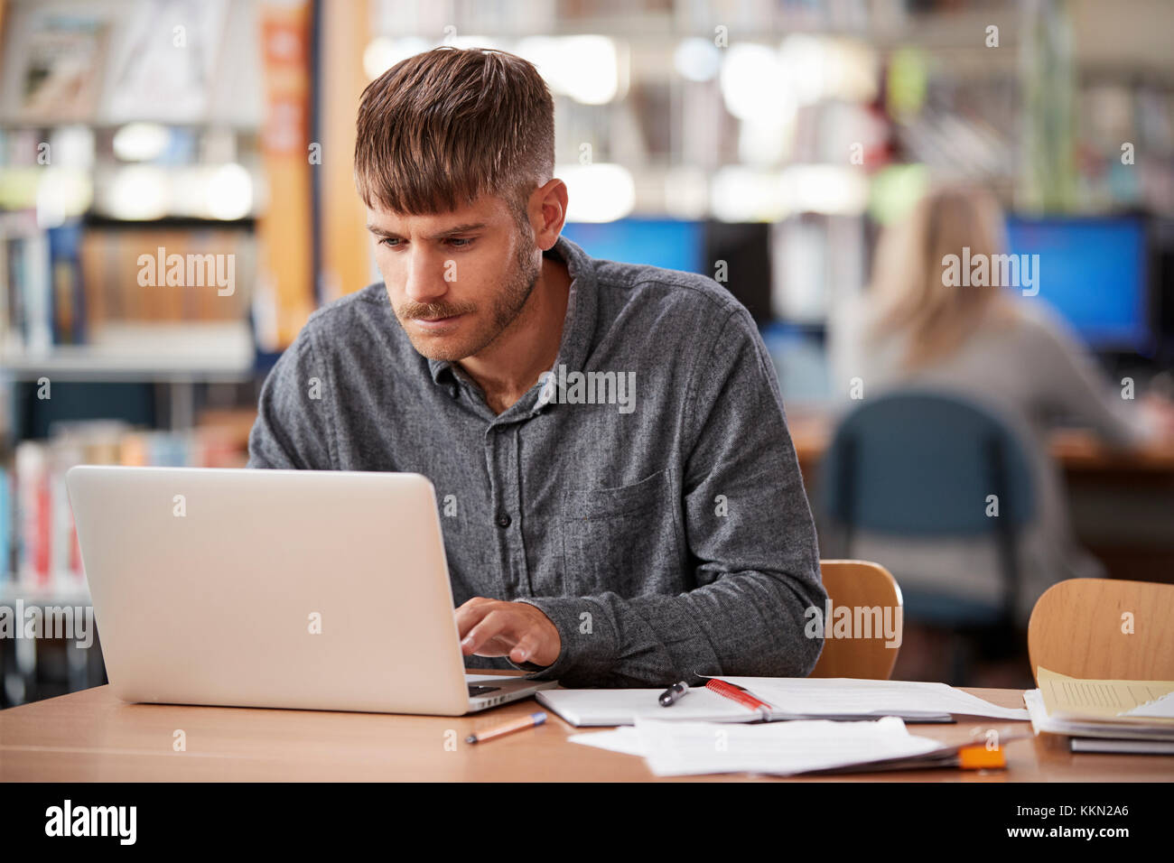 Reife männliche Kursteilnehmer Arbeiten am Laptop in der Hochschule Bibliothek Stockfoto