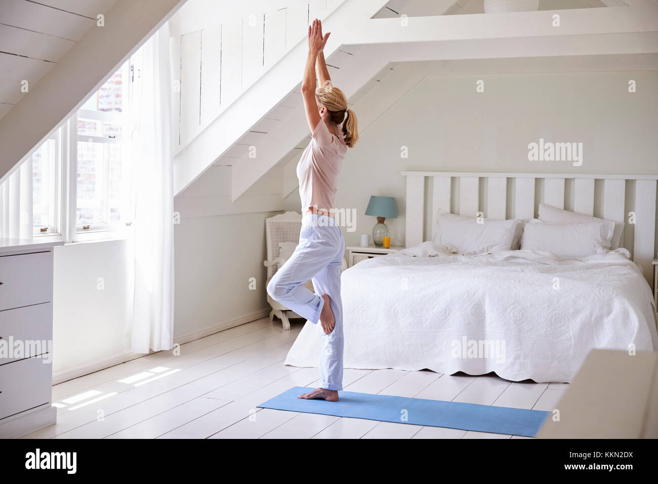 Frau zu Hause starten morgen mit Yoga Übungen im Schlafzimmer Stockfoto