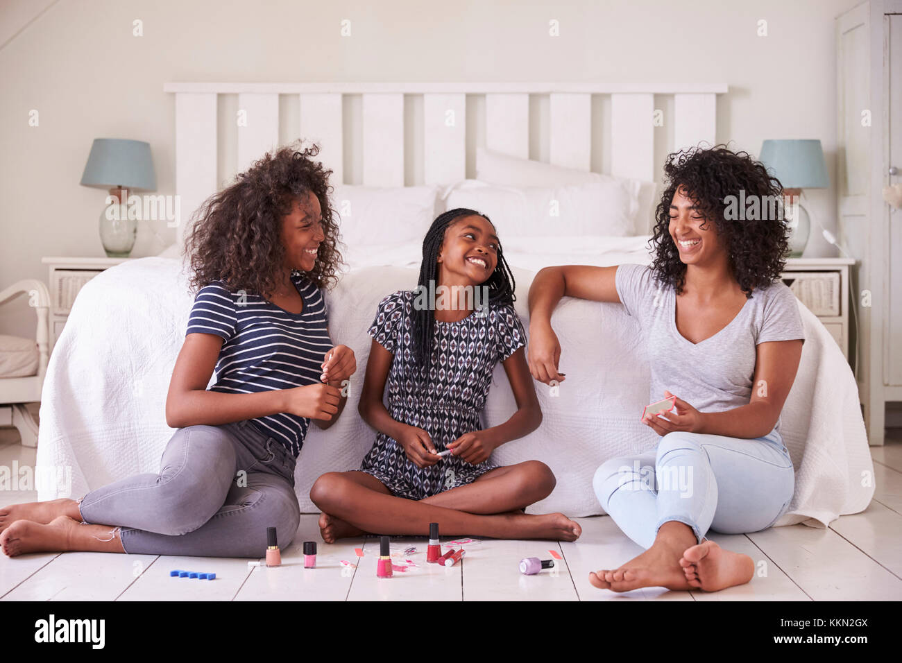 Drei Teenager Schwestern geben jedem anderen Umarbeitung im Schlafzimmer Stockfoto