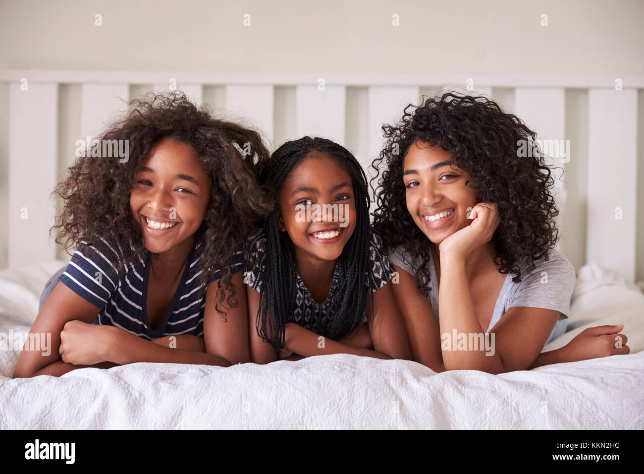 Portrait von drei Teenager Schwestern liegend auf Bett zu Hause Stockfoto