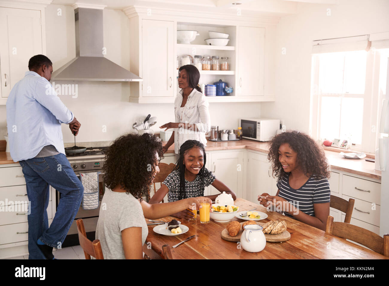 Familie mit Kindern im Teenageralter beim Frühstück in der Küche Stockfoto