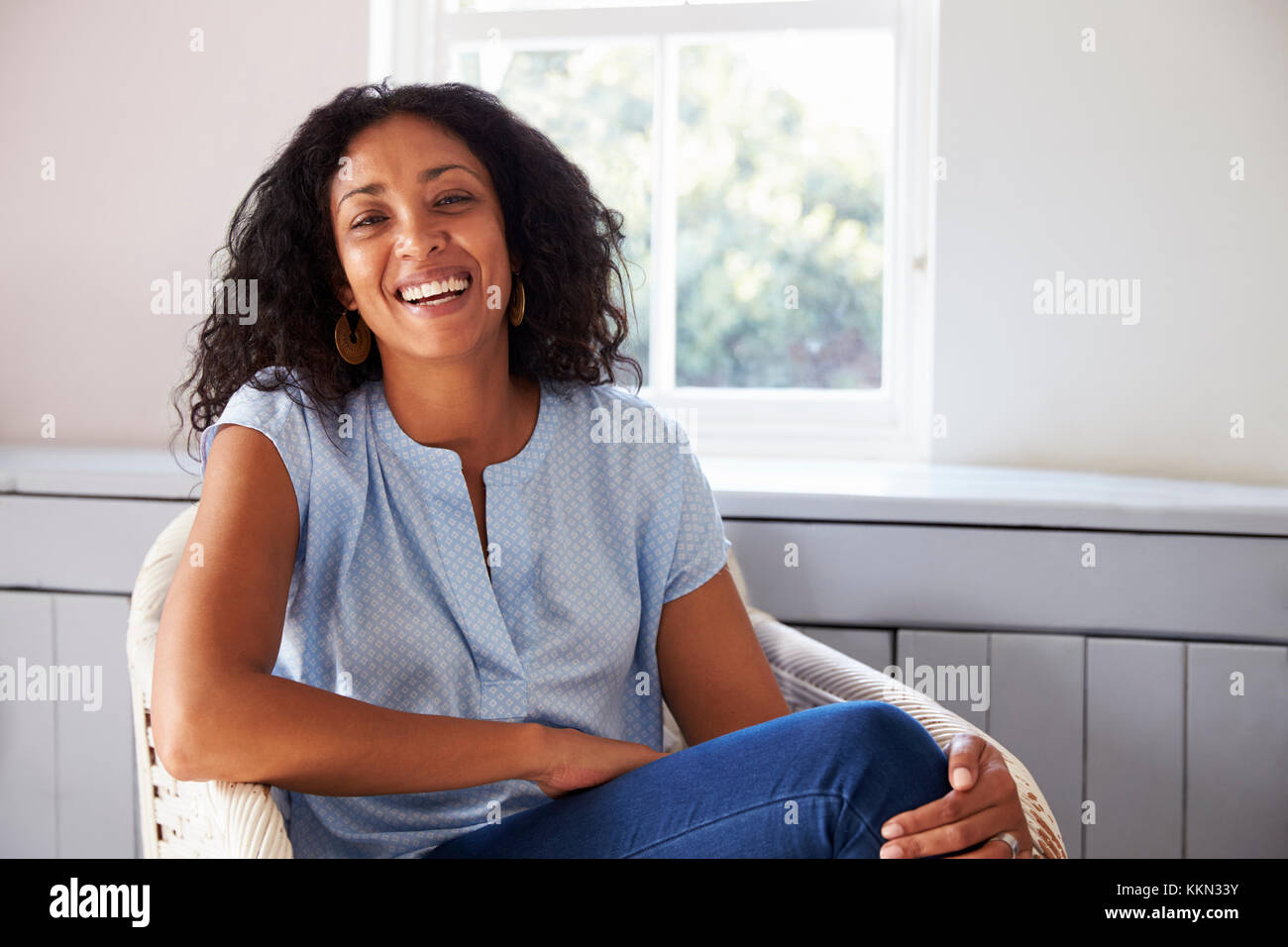 Portrait von Frau sitzt im Sessel zu Hause Stockfoto