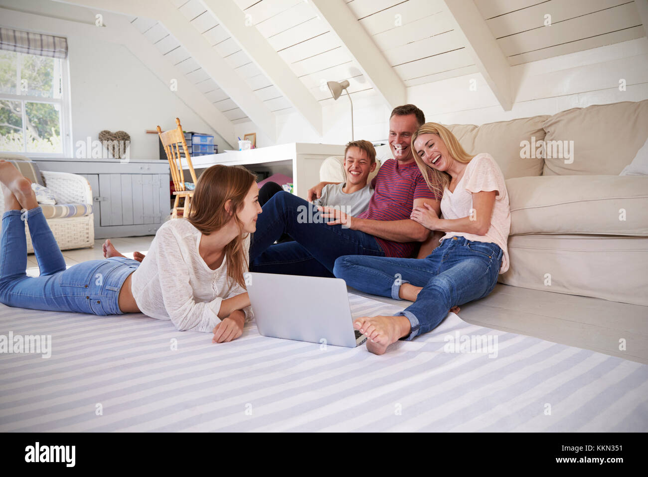 Familie mit Kindern im Teenageralter mit Laptop zu Hause Stockfoto